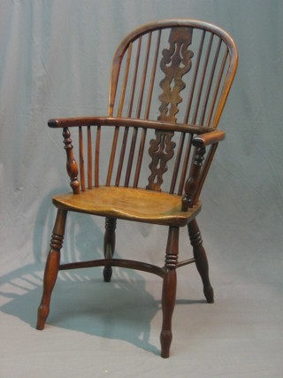 An 18th/19th Century elm and yew Windsor wheel back kitchen carver chair with Crinoline stretcher