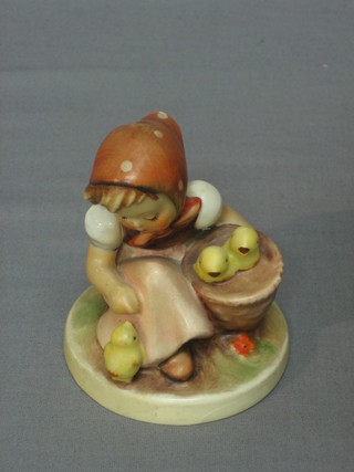 A Goebel figure of a seated girl feeding chicks (3 chips to the base) 4"