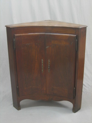 A 19th Century Continental mahogany concaved corner cabinet, the interior fitted shelves enclosed by panelled doors, 33"