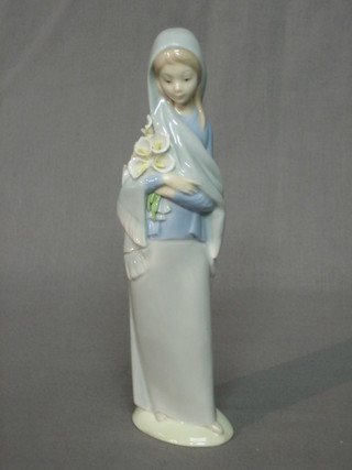 A Lladro figure of a standing lady with bunch of lilies (some lilies f) 9 1/2"