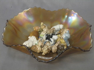 A pink Carnival glass dish containing a collection of various Wade Whimsies