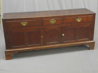 An 18th Century mahogany  dresser base fitted 1 short drawer flanked by 2 short drawers above a cupboard enclosed by panelled doors, raised on bracket feet 67" (split to top)
