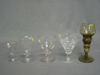 An antique glass rummer, a cut glass rummer and other wine glasses and a carved figure of a man with bucket