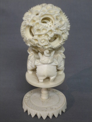 A carved ivory puzzle ball 2", raised on a stand