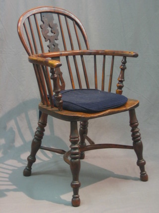 An 18th/19th Century elm and yew Windsor stick back carver chair with solid seat and pierced vase shaped slat back, having a cow horn stretcher (right leg cracked)