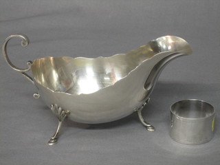 A Georgian style silver sauce boat with C scroll handled, raised on bun feet Sheffield 1909 and a silver napkin ring 6 ozs