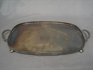 An oval silver plated twin handled tea tray, raised on bun feet