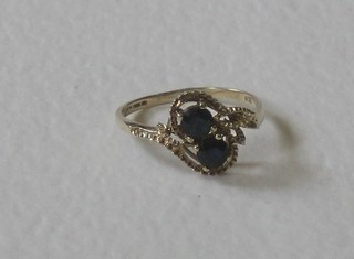 A lady's 9ct gold cross-over dress ring, set 2 sapphires