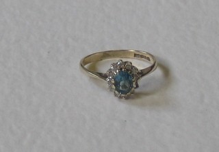 A lady's 9ct gold dress ring set an oval cut blue stone supported by diamonds