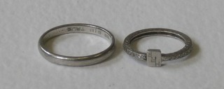 A platinum wedding band together with an eternity/signet ring