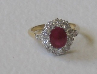 A lady's 18ct yellow gold dress ring set a large oval cut ruby supported by numerous diamonds, approx 0.90/1.35ct