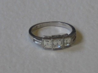 A lady's 18ct white gold dress ring set 3 square cut diamonds with baguette cut diamonds to the shoulders, approx 1.45ct