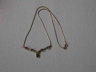 A lady's gold pendant set amethysts and diamonds hung on a fine gold chain
