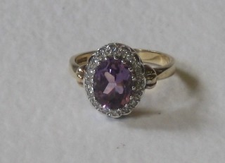 A lady's 9ct gold dress ring set an oval cut amethyst supported by diamonds