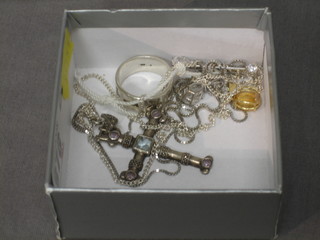 A silver cross hung on a fine silver chain, a silver ring, 3 various pendants