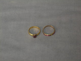 A 22ct gold band set an oval red stone together and a gilt metal ring set a red stone