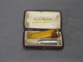 A silver and amber cigarette holder and an amber cigar holder
