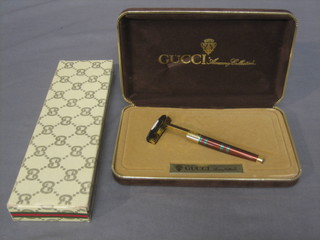 A Gucci razor in brown, green and red enamel together with Gucci toothbrush, both cased