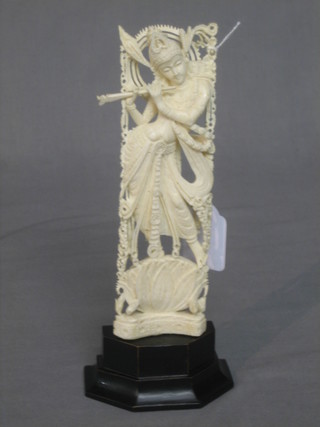 A pierced and carved ivory figure of a standing Deity 7", raised on an ebonised base