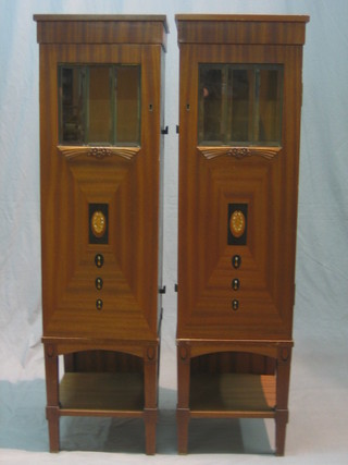 A pair of French Art Deco inlaid mahogany bedside cabinets enclosed by panelled doors with bevelled glazed plate panels above inlaid panels, 14"
