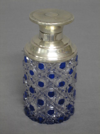 A cylindrical cut glass perfume bottle with blue overlay decoration, having a silver hinged lid 5"