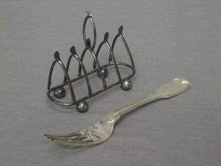 A William IV silver fiddle and thread pattern table spoon together with a silver plated 5 bar toast rack in the form of wish bones