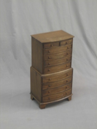 A Georgian style miniature bow front apprentice chest on chest, the upper section fitted 2 short drawers above 4 long drawers, the base fitted 4 long drawers with tore handles, raised on bracket feet 11"