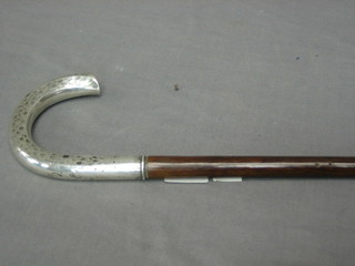A walking cane with silver handle