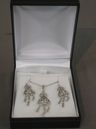 A "white gold" suite of jewellery comprising pendant and earrings