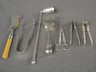 A pair of silver plated ice tongs, 2 pairs of silver plated sandwich salvers, 2 pairs of nut crackers, a candle snuffer and a pair of grape scissors