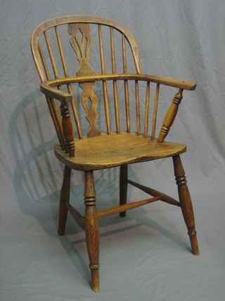 A 19th Century bleached elm stick back Windsor chair with vase shaped splat back, solid seat and raised on turned supports