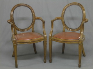 6 Edwardian oak framed open arm chairs with cane and leather reversible seats, raised on square tapering supports