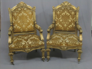 A pair of gilt painted French style open arm salon chairs with upholstered seats and backs