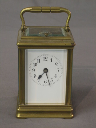 A 19th Century French striking carriage clock with Roman numerals,  contained in a gilt metal case