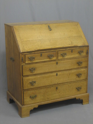 A 19th Century honey oak bureau, the fall front revealing a well fitted interior above 2 short and 3 long graduated drawers, raised on bracket feet 36"