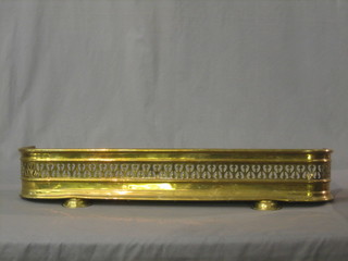 A Victorian pierced brass fire curb, raised on bun feet 30"