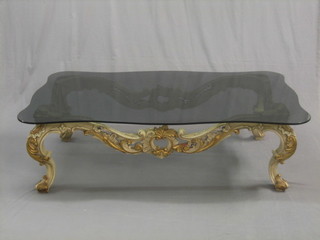 An Italian style carved coffee table with grey smoked glass top, raised on cabriole supports 60"