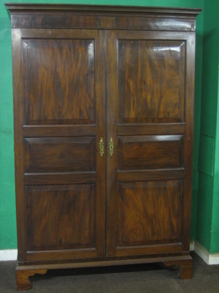A 19th Century Channel Islands mahogany wardrobe with moulded cornice and panelled doors, raised on bracket feet 51"