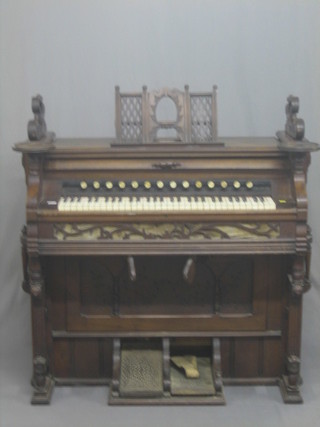 A Victorian harmonium contained in a walnut case by The Detroit Organ Company