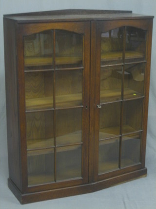 A 1930's oak display cabinet, the interior fitted adjustable shelves enclosed by astragal glazed panelled doors 35"