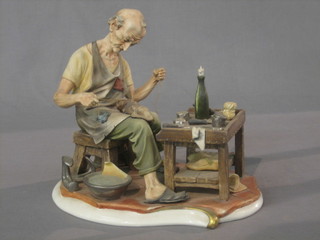 A Capo di Monte figure of a seated cobbler 9"