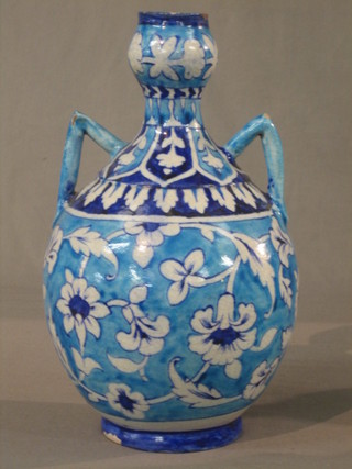 An Iznik pottery twin handled urn with blue floral decoration 12" high