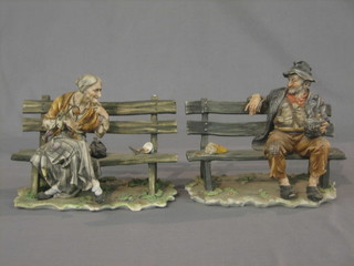 A Capo di Monte figure of a seated elderly lady sat on a park bench together with 1 other of a tramp 7" (2)