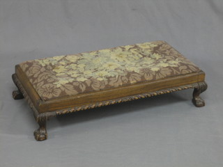 A rectangular carved mahogany footstool with gadrooned decoration raised on cabriole ball and claw supports 34"