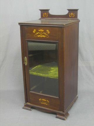 An Edwardian Art Nouveau inlaid mahogany music cabinet with hinged lid incorporating a music stand, the base fitted a cupboard enclosed by glazed panelled doors, raised on ogee bracket feet 18"