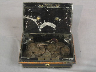 A small metal cap box containing a collection of old copper coins
