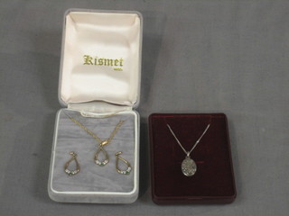 A "silver" locket and a gilt metal pendant set emeralds