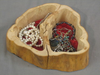 A rustic wooden trinket box containing various items of costume jewellery