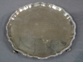 A circular silver salver with bracketed borders, raised on 4 scrolled feet, Birmingham 1964, 24 ozs