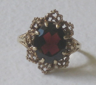 A gold dress ring set an oval cut red stone
